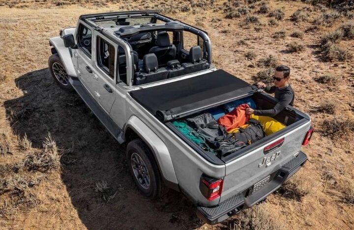 Aerial view showing a man packing cargo inside the pickup box of a grey 2022 Jeep Gladiator